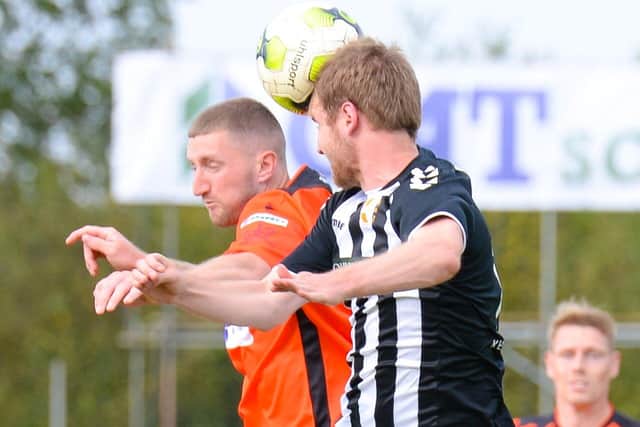 Two-goal Lee Wort, left, challenges for a header against Bemerton. Pic: Martyn White.