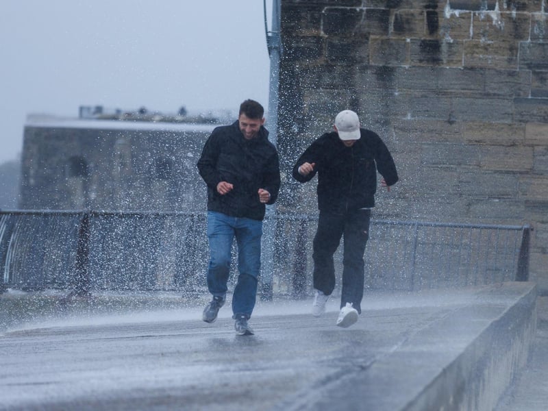 The stormy sea at high tide crashed waves onto footpaths as passer-by's did their best to get out the way