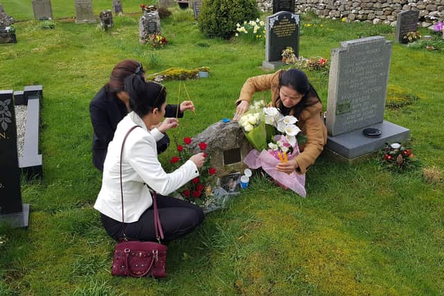 The grave of Lamduan Armitage being tended by members of the Thai Women Network in the UK.