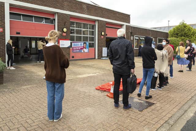 Residents queue outside Cosham fire station for Covid-19 jabs. Picture: Mike Cooter (300721)