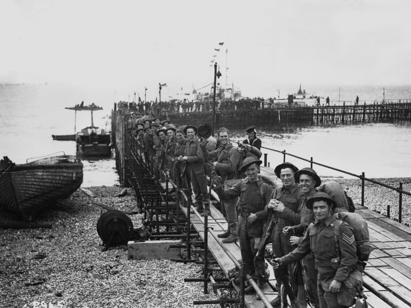 Troops line up on a temporary pier as they wait to embark