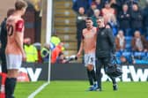 Regan Poole is helped off by physio Steve Hard following his ACL injury at Chesterfield in November. Picture: Simon Davies/ProSportsImages