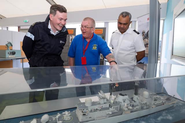 A Falklands veteran, centre, marvels at a model of the former destroyer HMS Glasgow, which survived being bombed during the Falklands War in 1982.
