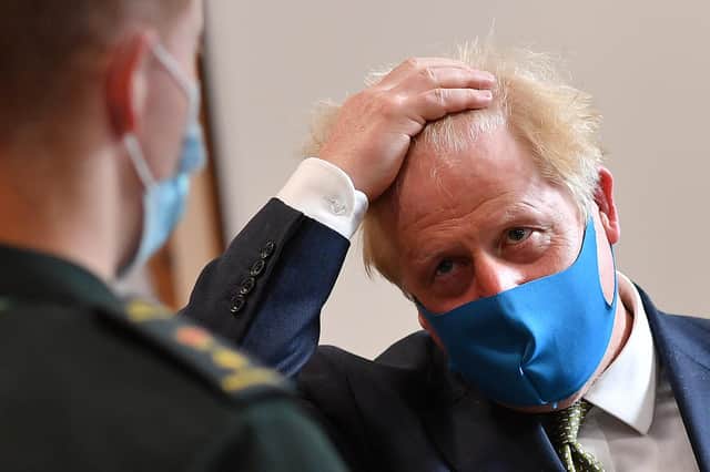 Britain's Prime Minister Boris Johnson, wearing a face mask due to the COVID-19 pandemic, talks with a paramedic as he visits the headquarters of the London Ambulance Service NHS Trust on July 13, 2020 in London, England. (Photo by Ben Stansall-WPA Pool/Getty Images)