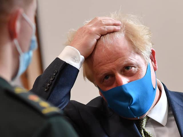 Britain's Prime Minister Boris Johnson, wearing a face mask due to the COVID-19 pandemic, talks with a paramedic as he visits the headquarters of the London Ambulance Service NHS Trust on July 13, 2020 in London, England. (Photo by Ben Stansall-WPA Pool/Getty Images)