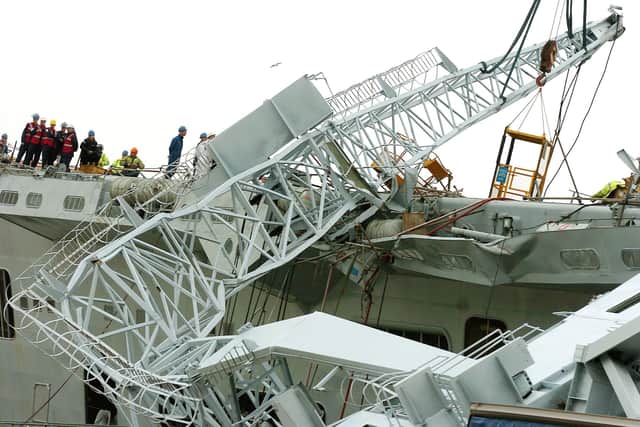 The jib of the fallen crane with the damaged deck. Engineers work to disentangle the crane from HMS Invincible. Picture: Matt Scott-Joynt (045492-162)