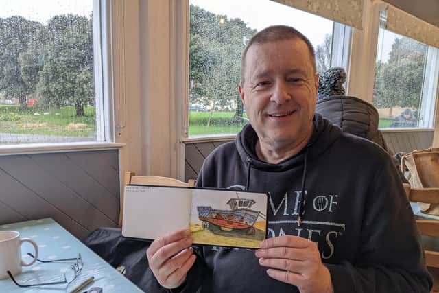 Paul White holds his sketchbook, showing a recent urban sketch. Picture: Emily Turner