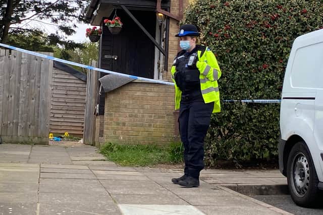 An officer guarding the house where the injured man was found. Photo: Tom Cotterill