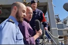 Diarmaid Ó Cadhla, centre, is ushered off the gangway of HMS Enterprise by a garda police officer in Cork, Ireland.