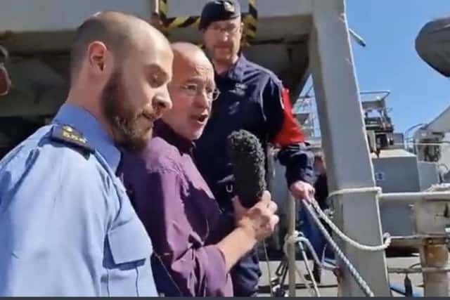 Diarmaid Ó Cadhla, centre, is ushered off the gangway of HMS Enterprise by a garda police officer in Cork, Ireland.