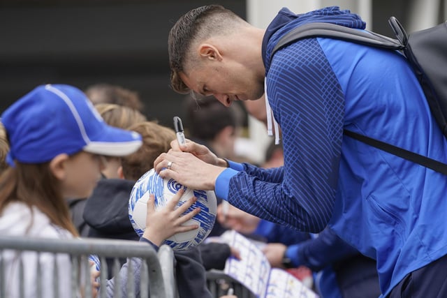 Goalkeeper Matt Macey signs a football for a young fans before taking his place in goal.