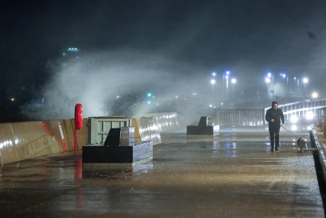 Waves crash over the sea wall near Clarence Pier.