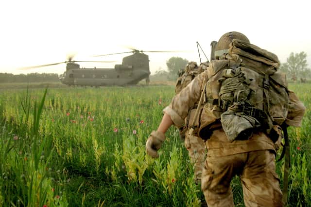 Soldiers in Afghanistan running up to a Chinook helicopter for extraction.