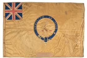 The Kellett sledge flag is made from silk, measures 595 by 885 mm within a frame of 710 by 995mm. The maker is unknown. The motto translates to Help From Above. Picture: NMRN