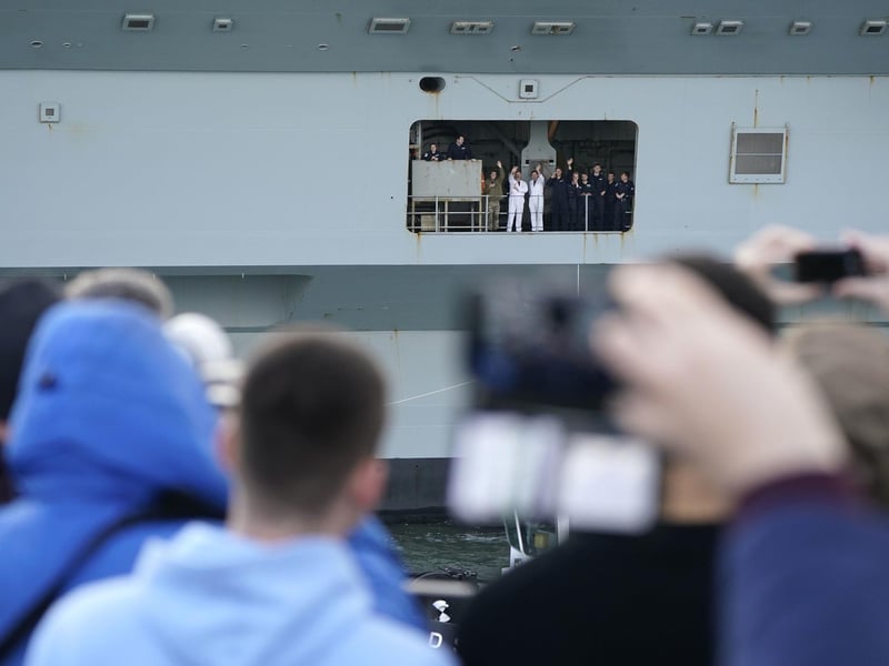 Crew members wave from the Royal Navy aircraft carrier, HMS Queen Elizabeth, as she leaves Portsmouth Harbour. Picture date: Friday November 3, 2023. PA Photo: Andrew Matthews/PA Wire