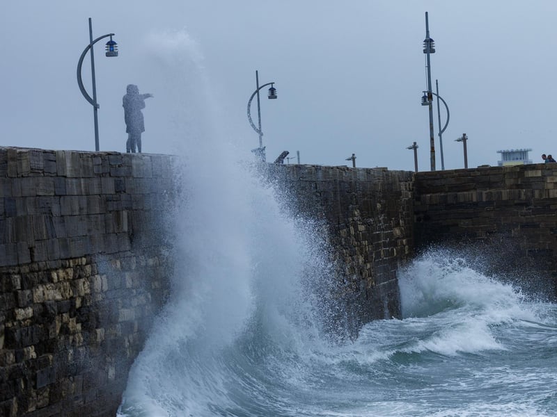 The stormy sea at high tide crashed waves onto footpaths as passer-by's did their best to get out the way