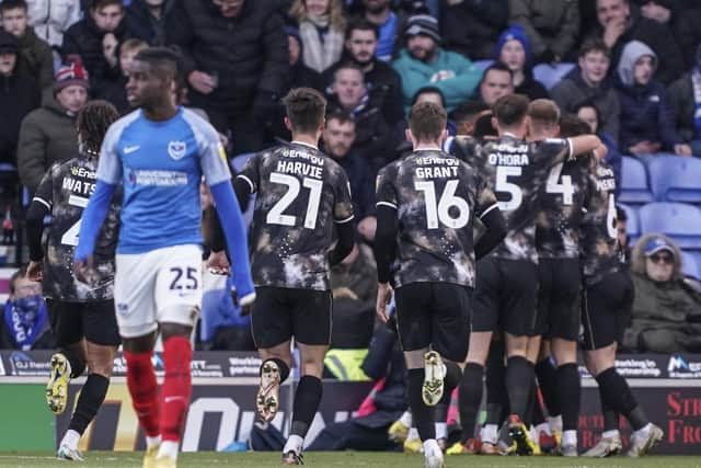 Bradley Johnson celebrates with his MK Dons team-mates after opening the scoring at Fratton Park.