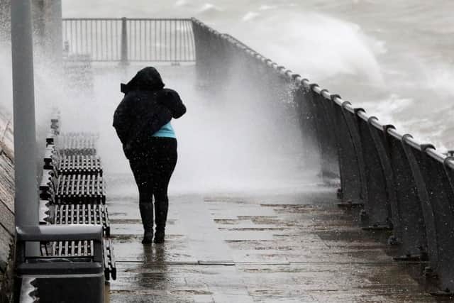 A resident struggles to walk as waves batter the Pompey coastline as Storm Ciara unleashes her wrath. Picture: Chris Moorhouse