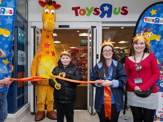 Lewis Harry, 8, who was first in the queue, cuts the ribbon, with manager Bryony Waldron, right, and other staff at the opening of Toys R Us shop in WHSmith, West Street, Fareham Picture: Chris  Moorhouse (231124-09)