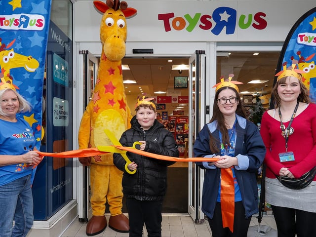 Lewis Harry, 8, who was first in the queue, cuts the ribbon, with manager Bryony Waldron, right, and other staff at the opening of Toys R Us shop in WHSmith, West Street, Fareham Picture: Chris  Moorhouse (231124-09)