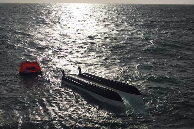 The capsized boat pictured following the rescue of its crew. Photo: Royal Navy.