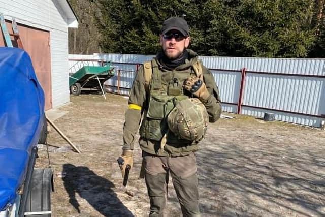 Shane Matthew, 34, of Chichester, narrowly avoided being hit by an artillery strike near Kyiv. Here he is pictured holding a pistol.