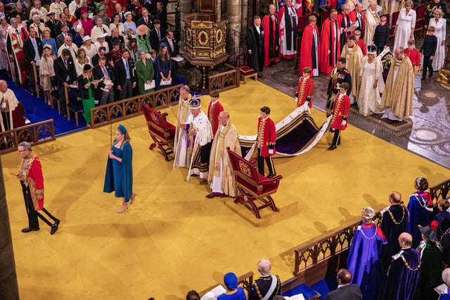King Charles III wearing St Edward's Crown, and Queen Camilla wearing Queen Mary's Crown, with Lord President of the Council, Penny Mordaunt, holding the Sword of State, during their coronation at Westminster Abbey, London.