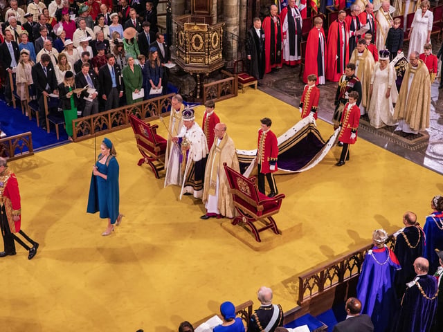 King Charles III wearing St Edward's Crown, and Queen Camilla wearing Queen Mary's Crown, with Lord President of the Council, Penny Mordaunt, holding the Sword of State, during their coronation at Westminster Abbey, London.