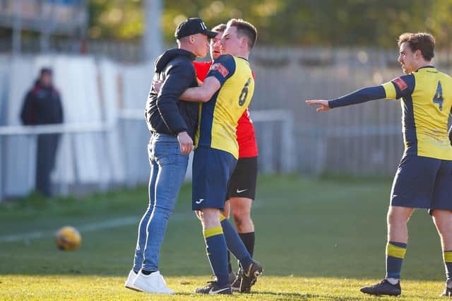 A Fareham Town spectator comes on the pitch to confront Moneyfields defender Tom Cain. Picture by Dave Boydmore.