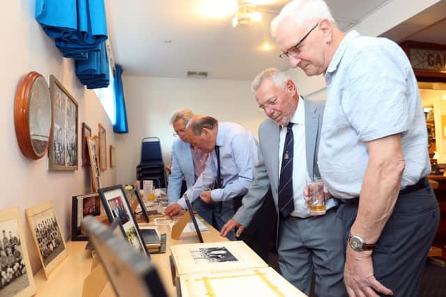 Les Donaldson, right, and Alan Cornish, second right, looking at old pictures and artefacts. Reunion of Paulsgrove school pupils who started school in September 1952. They are pictured at Victory Indoor Bowls Club, off Northern Parade, where they had a 70th anniversary dinner.