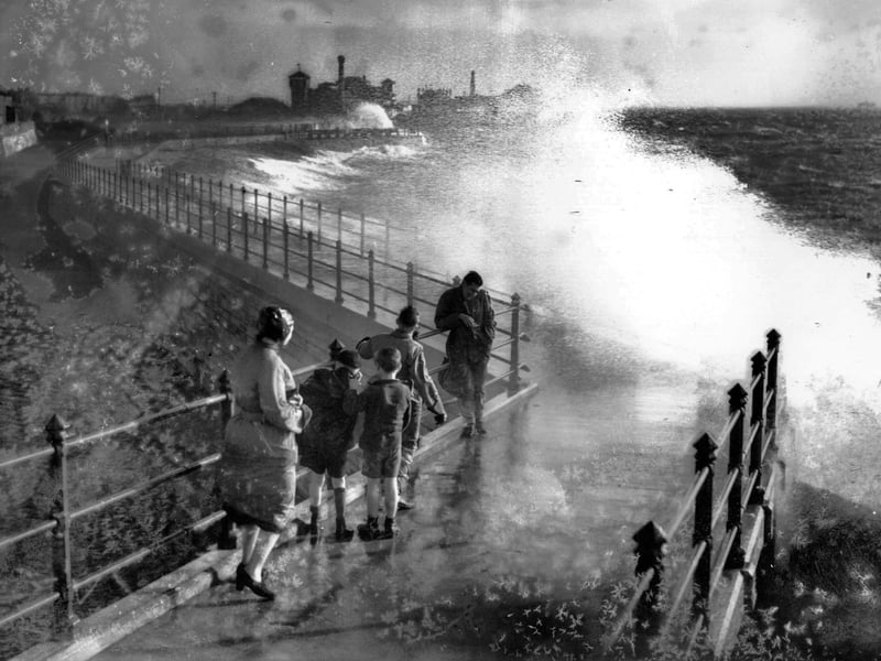 November 1938: People watching the huge seas breaking over Portsmouth Harbour. (Photo by David Savill/Topical Press Agency/Getty Images)