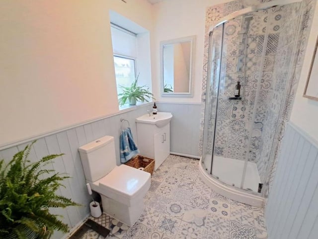 The bathroom has lovely tile detailing and it is one of two toilets within the property.
