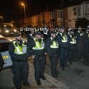 Over 100 illegal migrants aboard two RNLI lifeboats entered Portsmouth Harbour, arriving at Fort Blockhouse in Gosport, Hampshire on Sunday evening. Pictured just after midnight are dozens of police on Clayhall road in Gosport moving a large group of protesters before the buses leave  Credit: pictureexclusive.com