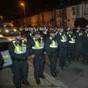 Over 100 illegal migrants aboard two RNLI lifeboats entered Portsmouth Harbour, arriving at Fort Blockhouse in Gosport, Hampshire on Sunday evening. Pictured just after midnight are dozens of police on Clayhall road in Gosport moving a large group of protesters before the buses leave  Credit: pictureexclusive.com