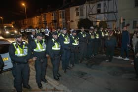 Over 100 illegal migrants aboard two RNLI lifeboats entered Portsmouth Harbour, arriving at Fort Blockhouse in Gosport, Hampshire on Sunday evening. Pictured just after midnight are dozens of police on Clayhall road in Gosport moving a large group of protesters before the buses leave Credit: pictureexclusive.com
