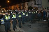 Over 100 illegal migrants aboard two RNLI lifeboats entered Portsmouth Harbour, arriving at Fort Blockhouse in Gosport, Hampshire on Sunday evening. Pictured just after midnight are dozens of police on Clayhall road in Gosport moving a large group of protesters before the buses leave  Credit: pictureexclusive.com