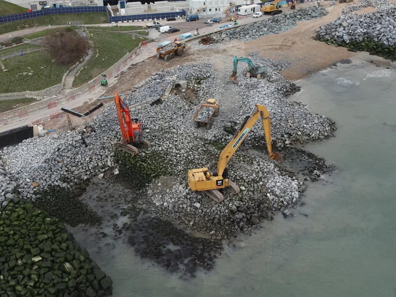 The base layer of the rock groyne is being installed