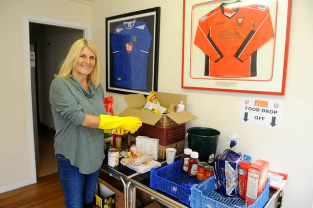 Penny Wilkinson cleaning down the donated tins and cartons before they are distributed to members of the local community. Picture: Sarah Standing