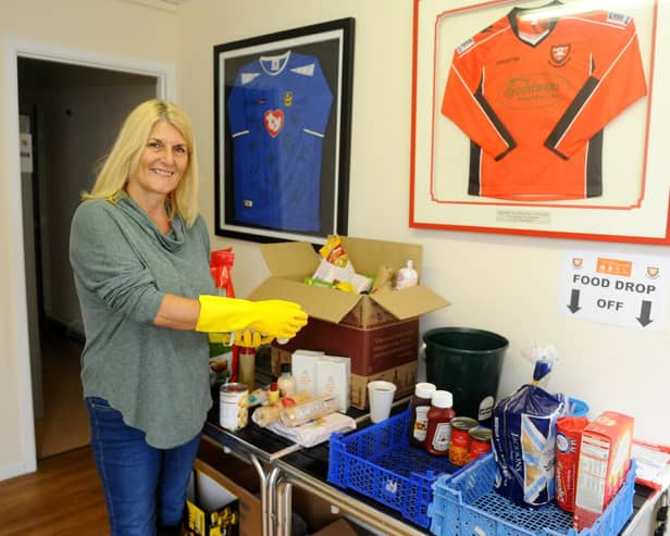 Penny Wilkinson cleaning down the donated tins and cartons before they are distributed to members of the local community. Picture: Sarah Standing