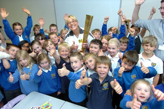 Olympic flame bearer Tina English dropped into Dore Primary School to give pupils a close up look at the torch she carried. Our picture shows her with pupils and teacher Andy Goodwin.