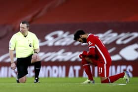 Referee Kevin Friend and Liverpool's Mohamed Salah take a knee in support of the Black Lives Matter. Pic: Clive Brunskill/PA Wire