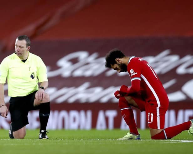 Referee Kevin Friend and Liverpool's Mohamed Salah take a knee in support of the Black Lives Matter. Pic: Clive Brunskill/PA Wire
