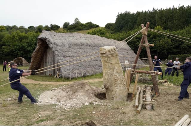 Crew members from HMS Queen Elizabeth and volunteers help raise a 3.5 ton standing stone, using only traditional methods, at Butser Ancient Farm to mark its 50 year anniversary