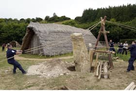 Crew members from HMS Queen Elizabeth and volunteers help raise a 3.5 ton standing stone, using only traditional methods, at Butser Ancient Farm to mark its 50 year anniversary
