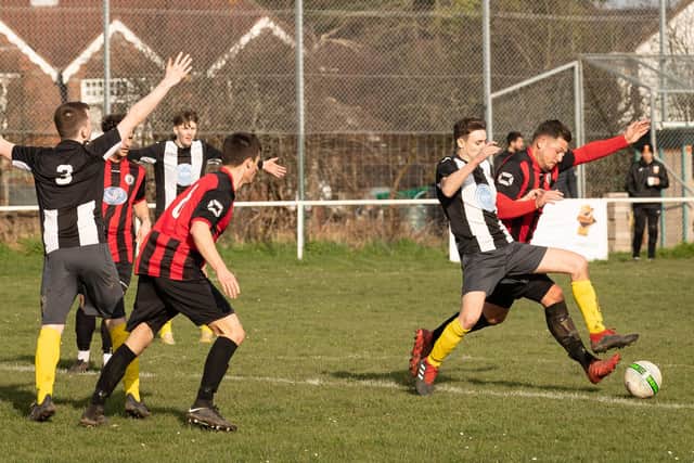 Locks Heath's Oli Adams is about to give away a penalty for this foul on Hayling's Sam Neal. Picture: Keith Woodland