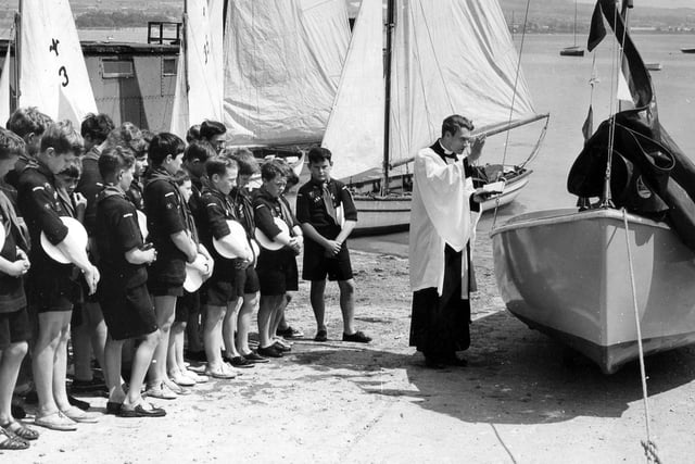 The Vicar of St. Mary's Portchester, the Rev Michael Thomas, dedicates a new dinghy for the Sea Scouts on the slipway at Portchester Sailing Club in 1966.