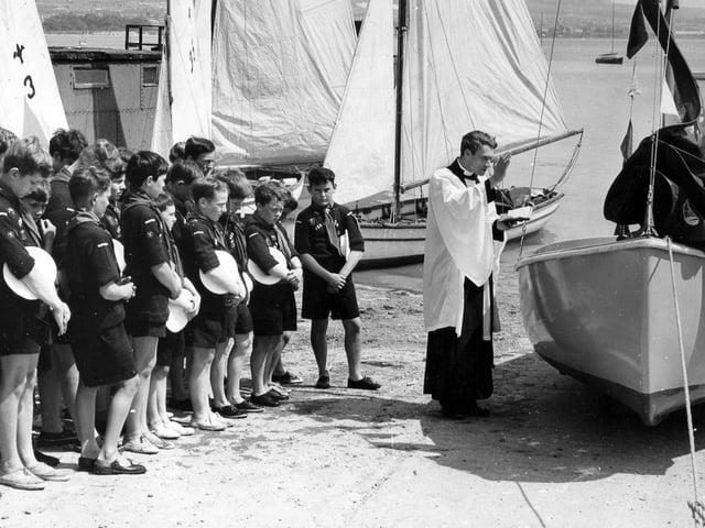 The Vicar of St. Mary's Portchester, the Rev Michael Thomas, dedicates a new dinghy for the Sea Scouts on the slipway at Portchester Sailing Club in 1966.