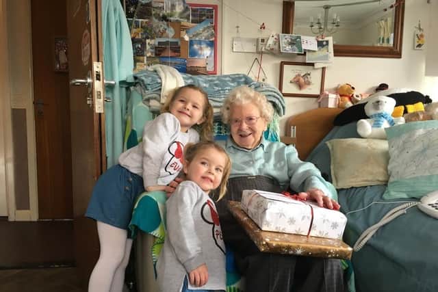 Eva and Pearl Chalmers presenting a gift to a care home resident in 2019 under the Christmas Pompey Present project.