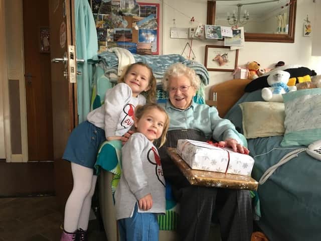 Eva and Pearl Chalmers presenting a gift to a care home resident in 2019 under the Christmas Pompey Present project.