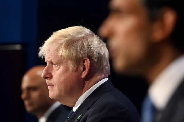 Prime Minister Boris Johnson (C), Britain's Health Secretary Sajid Javid (L) and Britain's Chancellor of the Exchequer Rishi Sunak attend a press conference inside the Downing Street Briefing Room in central London last year. Photo by TOBY MELVILLE/POOL/AFP via Getty Images.